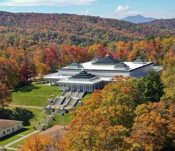 Art of Living Retreat Center building surrounded by autumn trees
